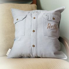 a light blue pillow with the name roly embroidered on it sitting on a chair