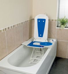 a white toilet sitting next to a bath tub in a bathroom with tile walls and floor