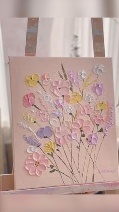 an easel with flowers painted on it