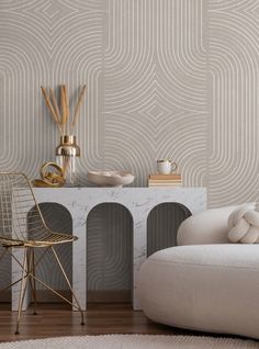 a white chair sitting next to a table on top of a hard wood floor in front of a wall