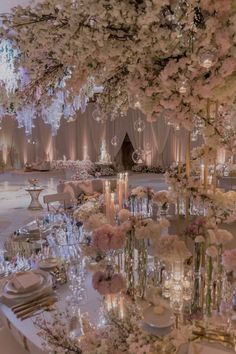 an elegant wedding setup with flowers, candles and chandeliers on the ceiling is ready for guests to arrive