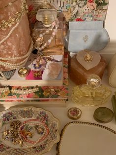 an assortment of jewelry is displayed on a counter top next to other decorative items and accessories