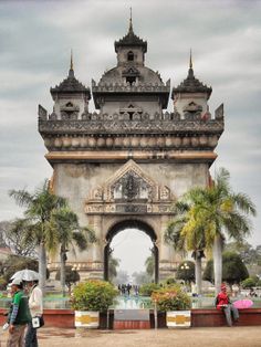 two people walking in front of an ornate gate