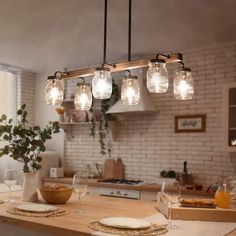 a kitchen island with lights hanging from it's ceiling and plates on the counter