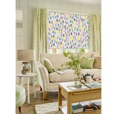 a living room filled with furniture and a window covered in colorful blinds on the windowsill