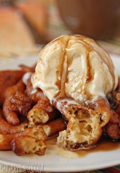 a white plate topped with waffles covered in ice cream and caramel sauce