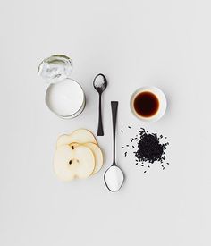 an assortment of ingredients including apples, milk and sugar on a white surface with spoons