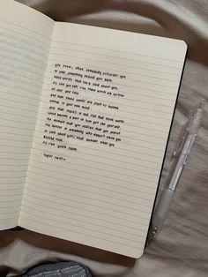 an open book with writing on it next to a pen