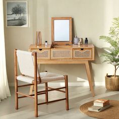 a wooden desk with a mirror on top of it next to a potted plant