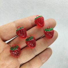 four miniature strawberries in the palm of someone's hand