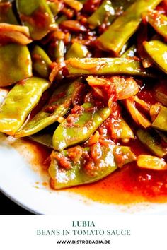 a white plate topped with beans covered in sauce