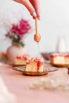 a piece of cake on a plate being lifted with a fork by a wooden stick