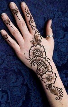 a woman's hand with henna tattoos on it