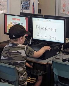 a young boy sitting at a desk using a computer