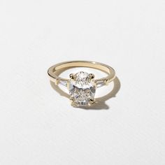 a yellow gold ring with an oval cut diamond