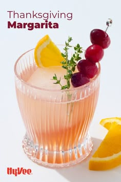 a glass filled with fruit and garnish on top of a table