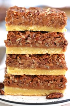 three slices of pecan bars stacked on top of each other with nuts around them