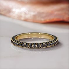 the Monoceros Pave 2-Sided Half Eternity Stackable Ring, a captivating piece crafted in 14K yellow gold, blending celestial charm with modern elegance. This ring features a total of 1 carat in mesmerizing black diamonds, each meticulously treated to exhibit a deep, enigmatic hue that symbolizes the mysterious allure of the night sky.The round-cut side diamonds, carefully arranged on both sides of the band, create a sleek, contemporary look, making this ring not just a piece of jewelry, but a sym Elegant Yellow Gold Rings With Black Spinel, Elegant Yellow Gold Ring With Black Spinel, Luxury Black Stackable Rings For Anniversary, Elegant Gold Ring With Black Spinel, Celestial Yellow Gold Stackable Rings, Elegant Gold Rings With Black Spinel, Formal Yellow Gold Rings With Black Spinel, Celestial Yellow Gold Stackable Jewelry, Luxury Gold Eternity Band