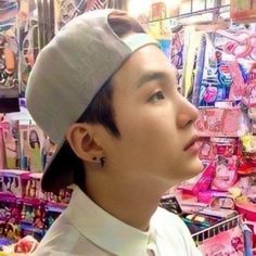 a young man wearing a hat and looking up at the sky in a toy store