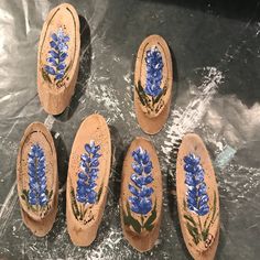 six wooden shoes with blue flowers painted on them