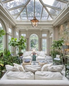 a living room filled with lots of furniture and plants on top of it's walls