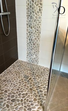 a bathroom with a walk in shower next to a stand up shower head mounted on the wall