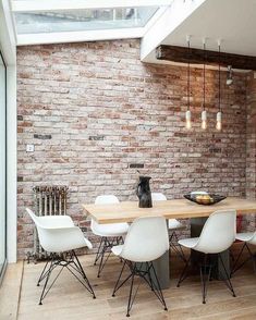 a dining room with brick walls and white chairs