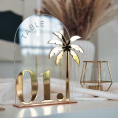 a glass table number with a palm tree on it