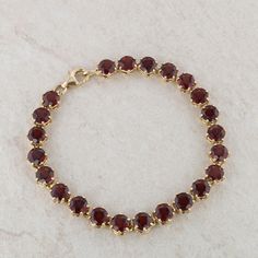 This ladies 14k yellow gold bracelet has round faceted red garnets that are set in a 6 prong basket setting. There are twenty-three garnets that measure 5.5mm each. The bracelet measures 7" inches in length and 7.1mm in width. It weighs 14.13 grams and has a lobster clasp. Condition: Pre-Owned *All items are thoroughly inspected for quality assurance purposes Classic Gold Ruby Tennis Bracelet, Classic Gold Bracelet With Birthstone, Classic Faceted Round Bracelets, Gold Jewelry Sets, Garnet And Gold, Garnet Bracelet, Yellow Gold Bracelet, Fine Jewelry Bracelets, Wedding Jewelry Bracelets