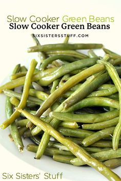 a white plate topped with green beans on top of a table