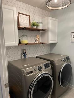 a washer and dryer in a small room with white cupboards on the wall