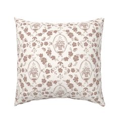 a white and brown pillow with flowers on it