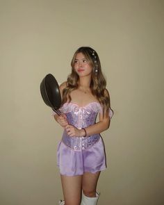 a woman in a purple corset holding a frying pan