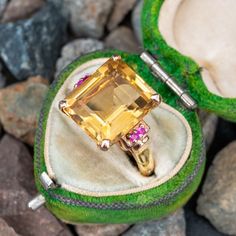 This gorgeous retro vintage ruby and citrine cocktail ring features a centered emerald cut citrine that is accented to each side with two (2) round rubies. The top of the ring is crafted in 14k rose gold. The shank has been replaced with a 14k yellow gold Finger Mate shank which can open and close if you need help getting over the knuckle. The ring is a size 5.25 and cannot be sized. The citrine shows light chips and abrasion. Antique Cocktail Ring, Citrine Jewelry, Setting Ideas, Ancient Jewelry, Citrine Ring, Rose Yellow, Ring Setting, Cocktail Ring, Modern Jewelry