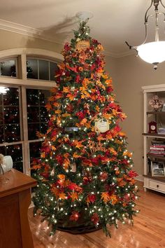 a decorated christmas tree in a living room next to a window with lots of lights