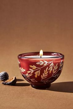 a candle that is sitting in a bowl next to some kind of nutmeal