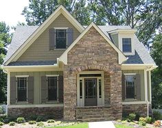 a brick and stone house with black shutters on the front door is shown in this image