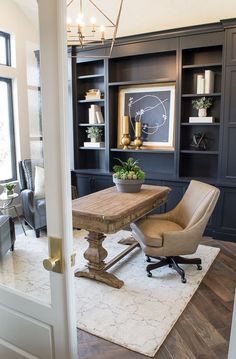 a chair and table in a room with built - in bookcases on the wall