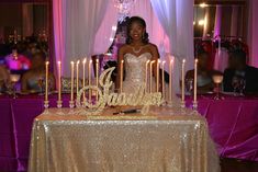 a woman standing in front of a cake with candles on it at a wedding reception