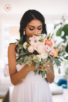 a woman holding a bouquet of flowers in her hands