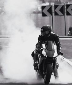 a man riding on the back of a motorcycle down a street