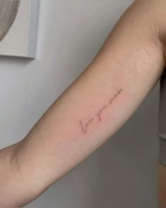 a woman's arm with the word love written in cursive writing on it