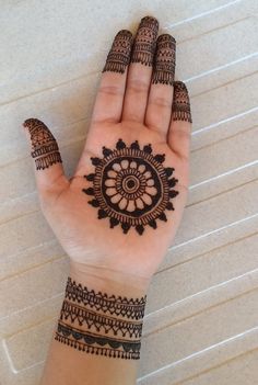 a woman's hand with henna tattoos on it