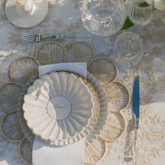 the table is set with plates, silverware and napkins for an elegant dinner