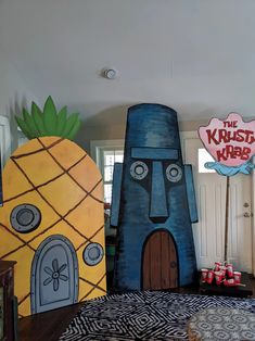 three giant pineapples and a house made out of cardboard are on display in the living room