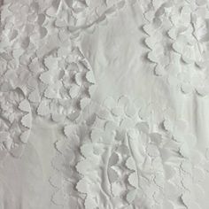 an image of white fabric with flowers on it