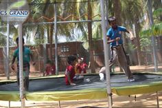 children are playing on a trampoline in the park