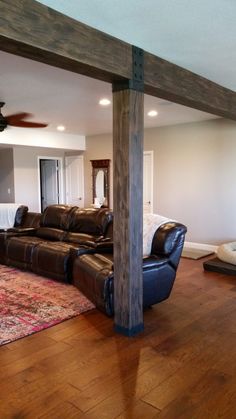 a living room with leather couches and a rug on the floor in front of a ceiling fan