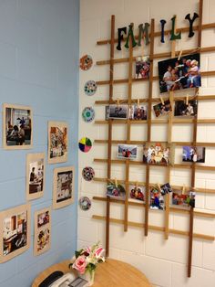 a room with pictures on the wall and photos hanging on the wall behind a table