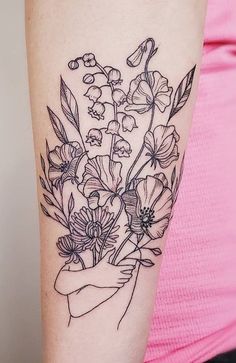 a woman's arm with flowers and leaves tattoo on the left side of her arm